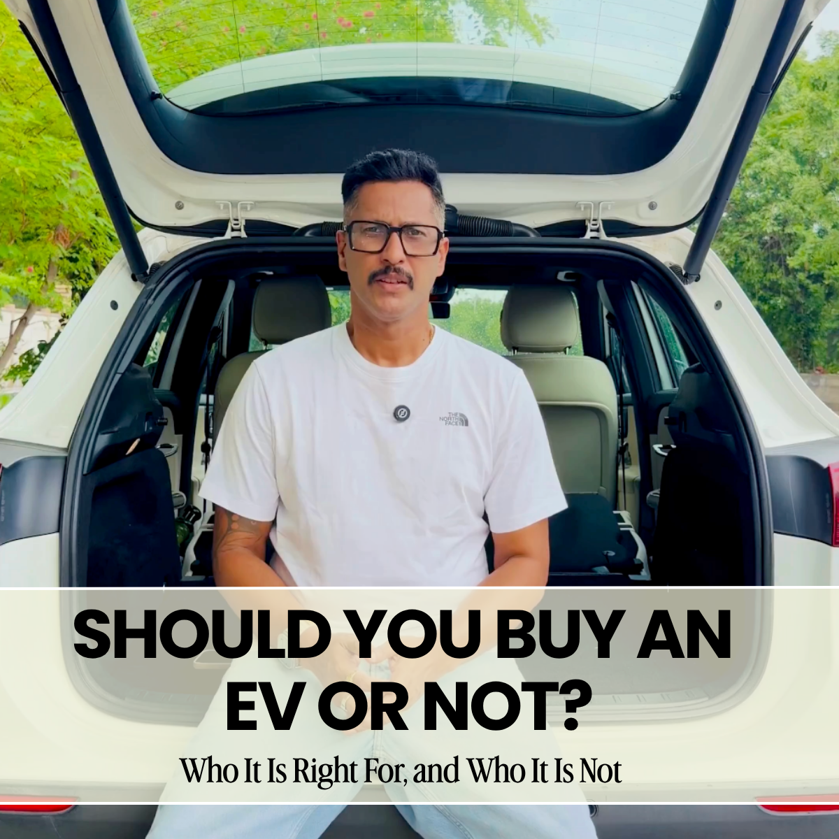 Saagar Kumar Mishra sitting at the rear of an electric car with the title Should You Buy an EV or Not?